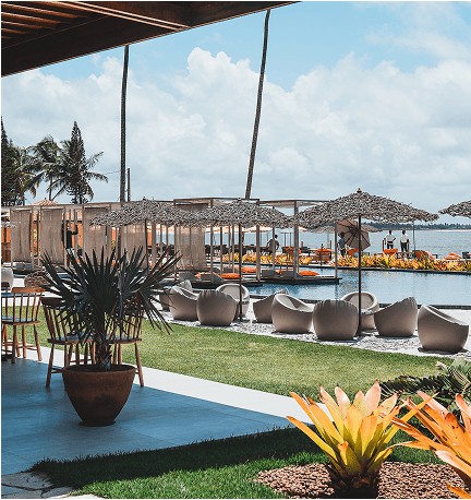 Lounge Família - Espaço confortável com almofadas brancas e vista para o mar